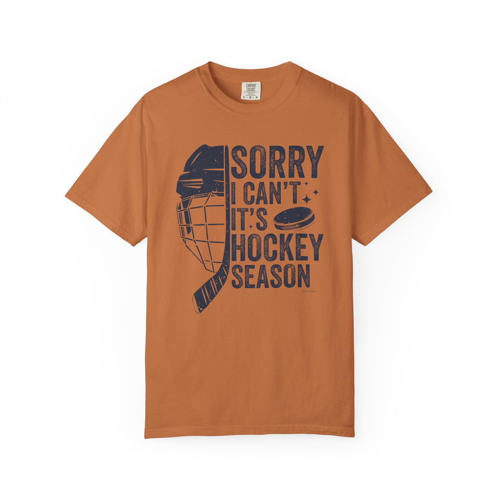 Brown t-shirt with hockey-themed graphic and text on a white background