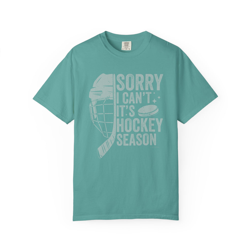Teal t-shirt with hockey-themed text and graphics on a white background