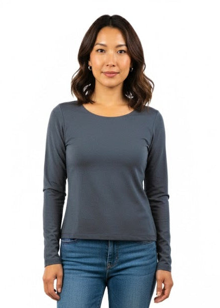 Woman wearing a TENCEL clothing gray long-sleeve top and blue jeans on a white background